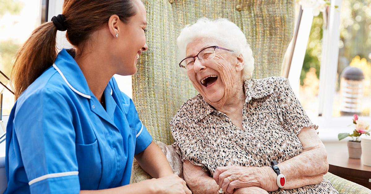 Senior and caregiver laughing