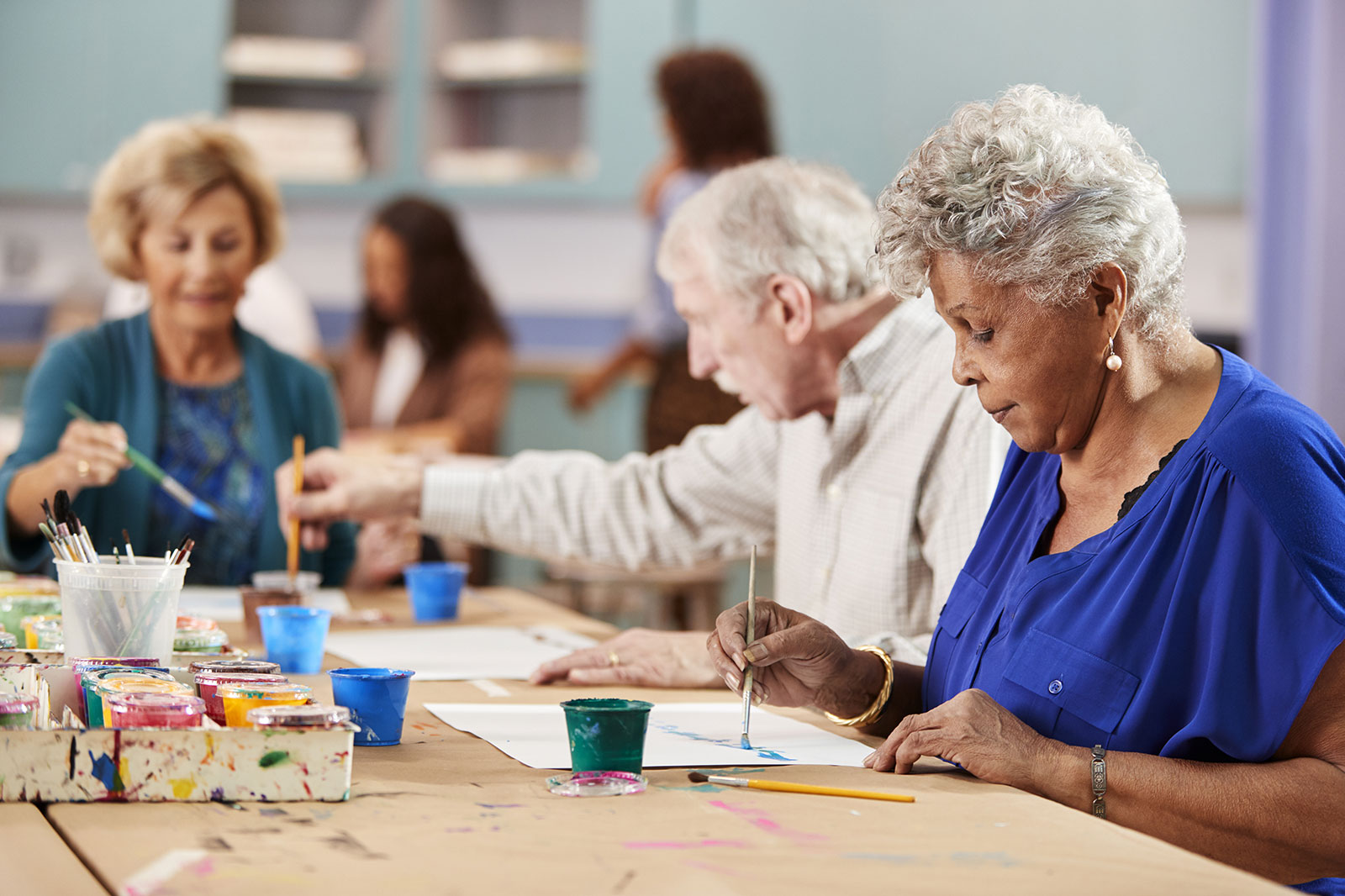 Senior citizens paint with watercolors
